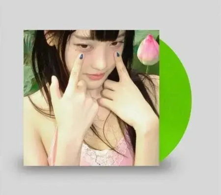 A square album cover featuring a close-up portrait of a young woman with her fingers near her eyes, next to a bright green vinyl record on a light gray background.